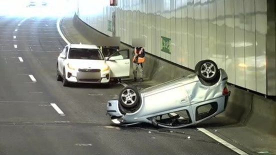 Lange tijd flinke vertraging in tunnel door auto die op zijn kop ligt na ongeluk. Lange tijd flinke vertraging in tunnel door auto die op zijn kop ligt na ongeluk.