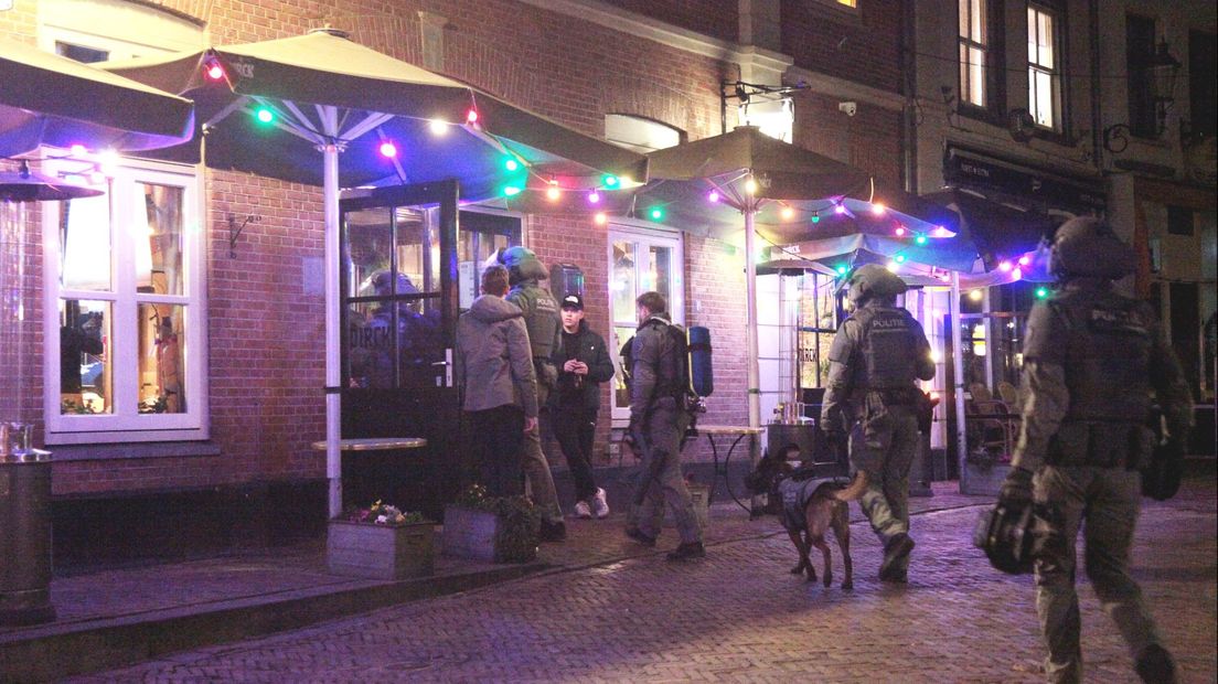 Een arrestatieteam gaat naar binnen in horecagelegenheid Dikke Dirck aan de Groenmarkt. De verdachte zat overigens niet in die horecazaak.