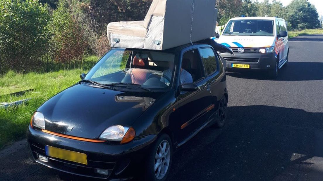 Het autootje met het bankstel langs de snelweg.