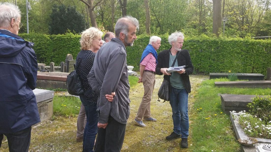 Gids Henk Bakker (rechts) met bezoekers.