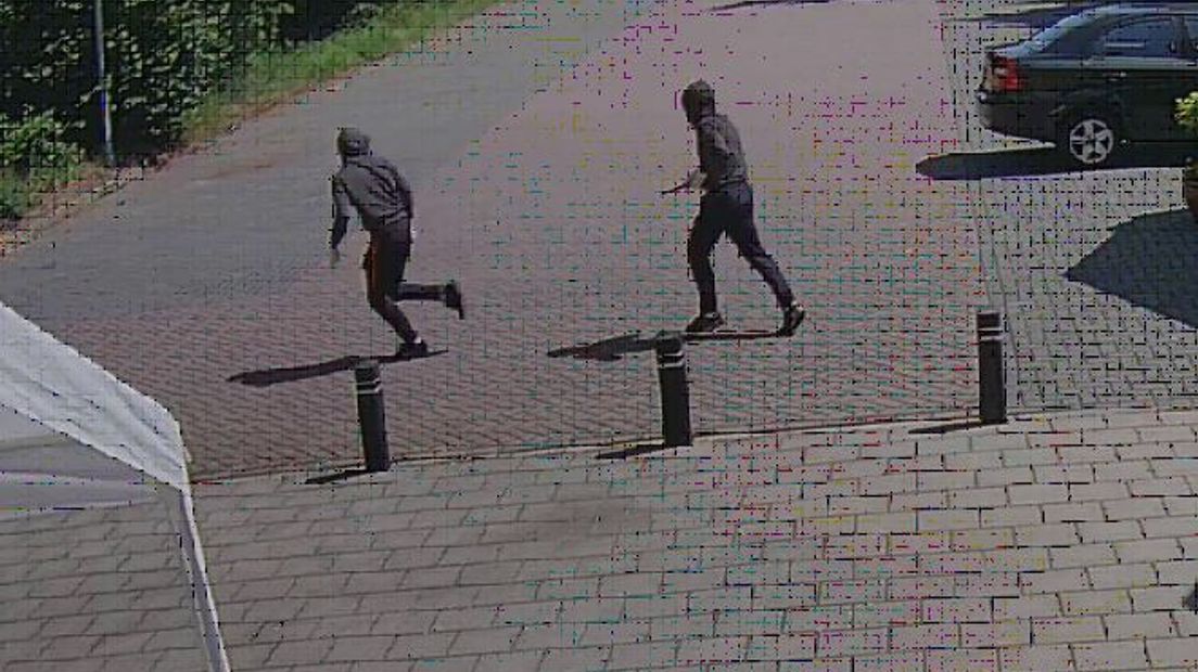 De twee daders rennen na de mishandeling weg. De foto is een still van een beveiligingscamera bij de hindoetempel.