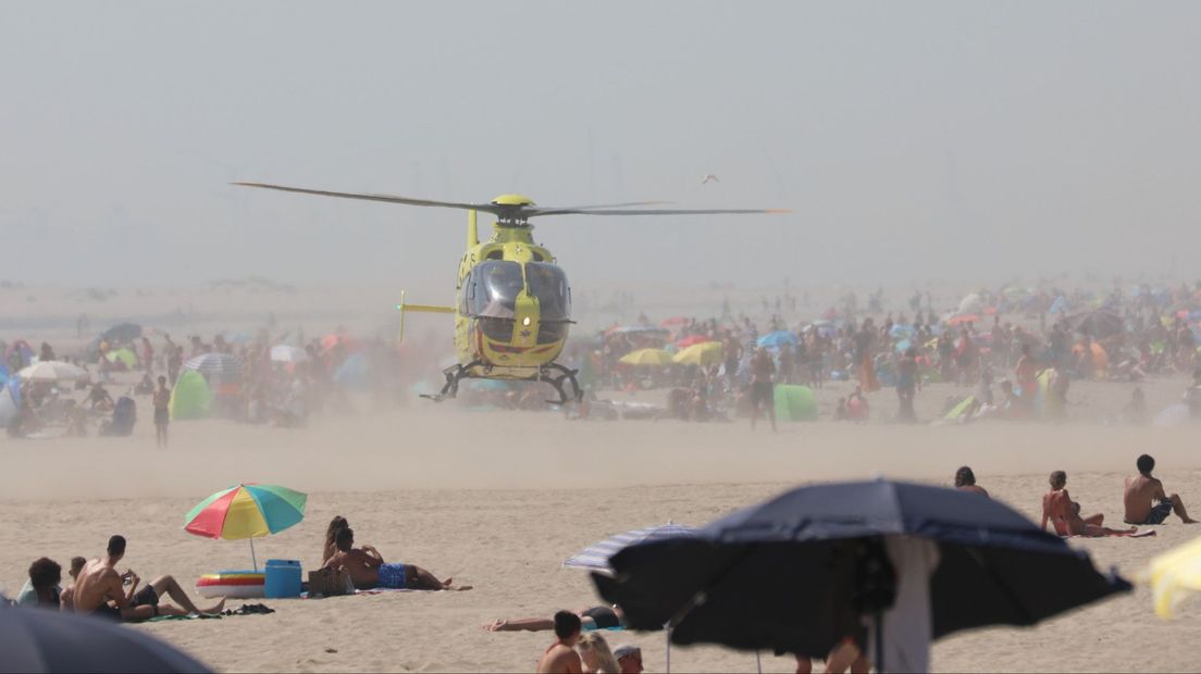 Helikopter landt op het strand tussen de badgasten