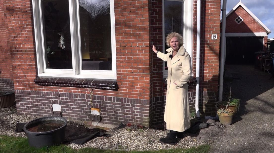 Femke Braamhorst toont de scheuren in de voorgevel van haar huis