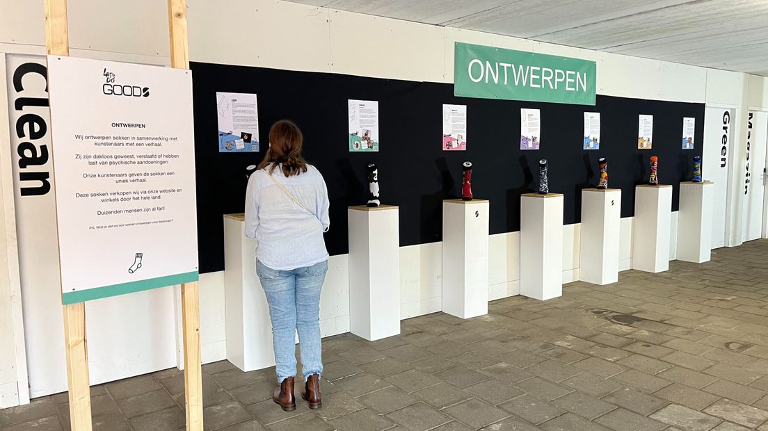 Een bezoeker bekijkt de collectie kunstsokken en hun verhalen