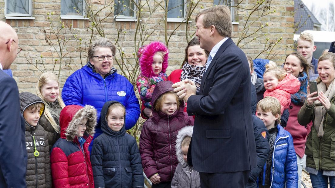 Koning begroet kinderen van naastgelegen basisschool