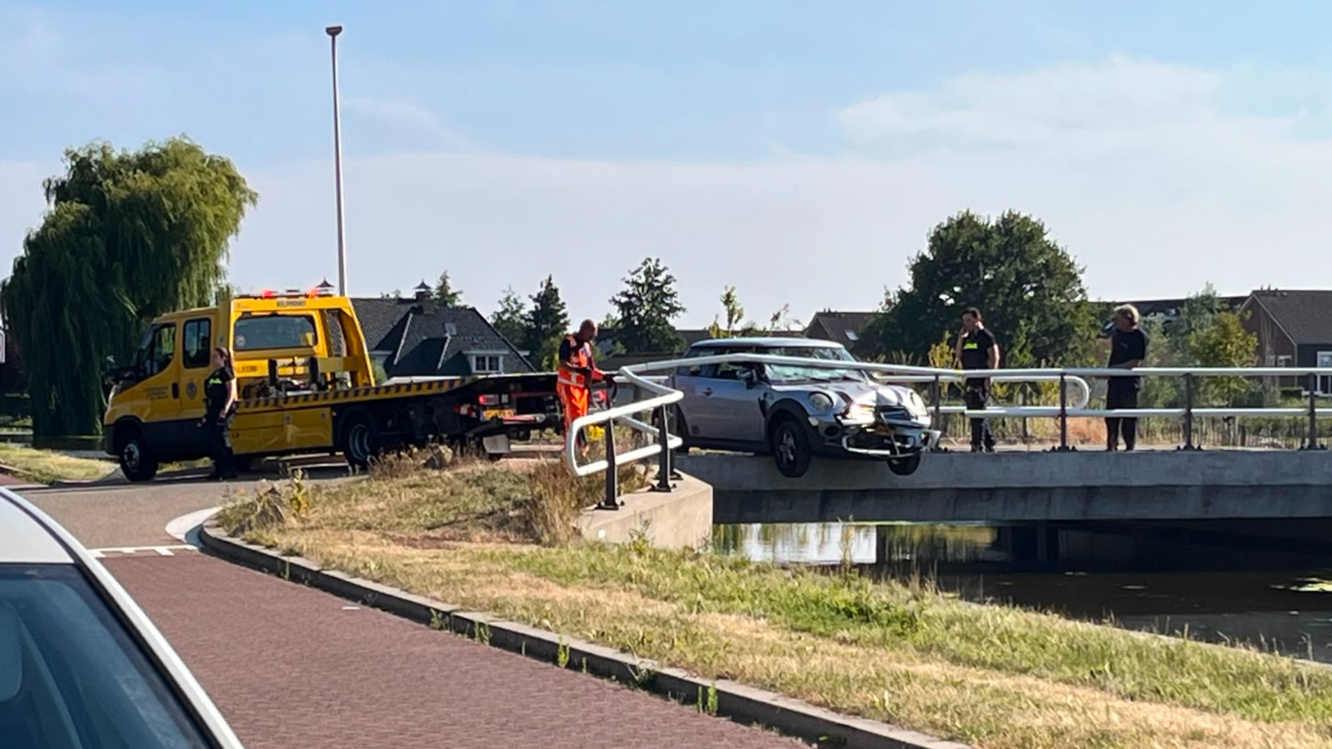 Een berger heeft de auto tussen de brugreling vandaan gehaald en afgesleept.
