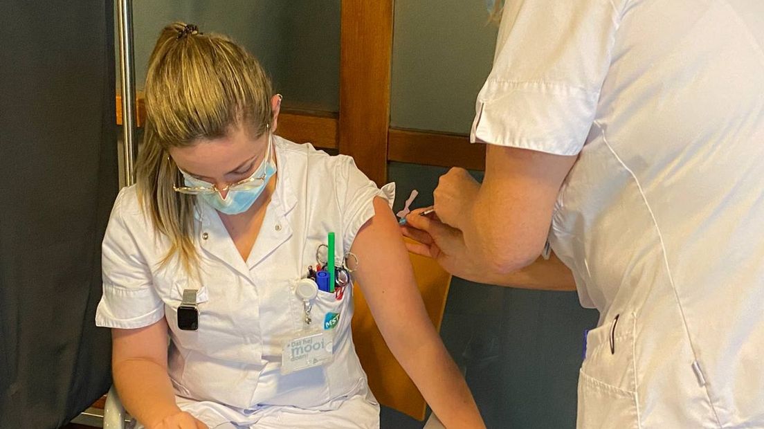 Een MST-medewerkster krijgt het vaccin toegediend tegen het coronavirus