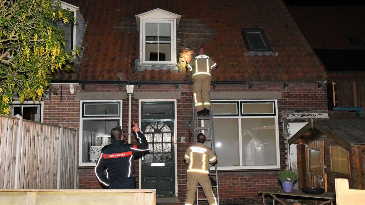 Man loopt over daken en gooit dakpannen naar beneden