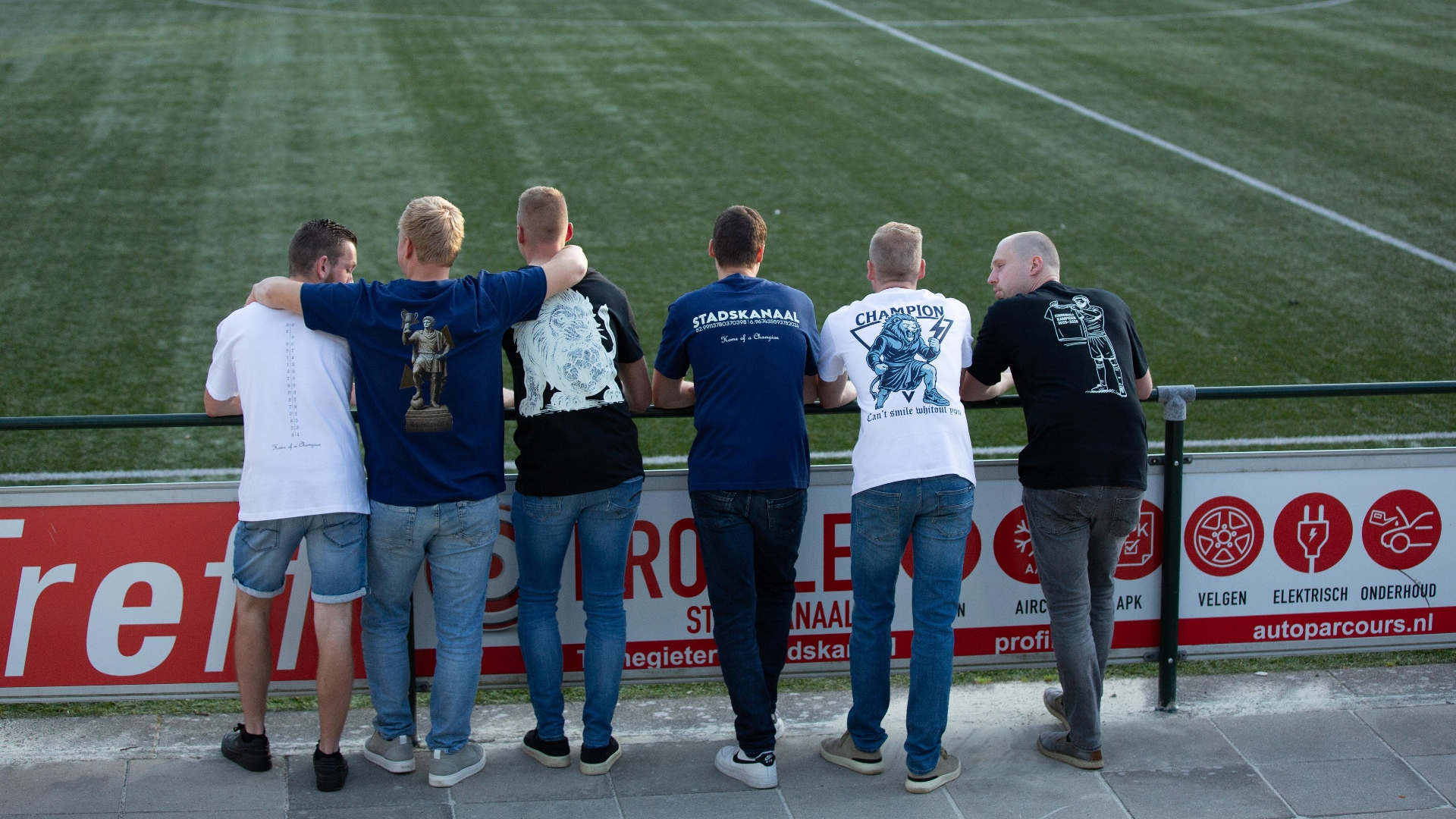 In kampioensshirts staan de jongens langs het veld