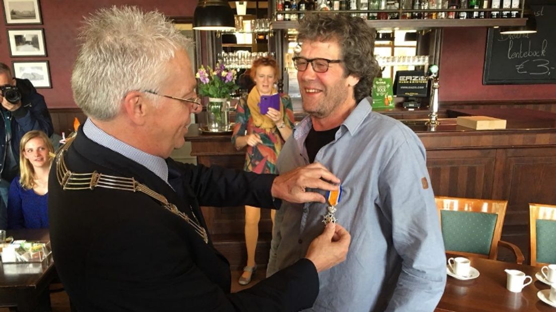 Melkschapenhouder Leo de Vos uit Peize krijgt een lintje opgespeld door loco-burgemeester Hens Kosters van Noordenveld in Cafe Ensing in Peize (Rechten: RTV Drenthe)