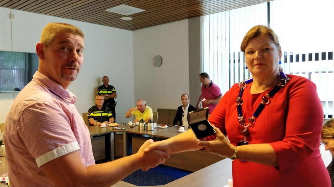 Johan Haarhuis krijgt van burgemeester Wilmien Haverkamp een medaille voor zijn heldendaad