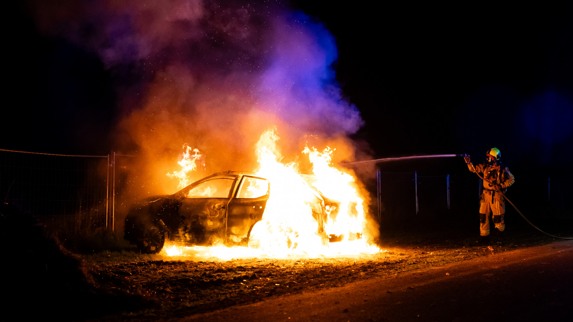 De brandweer blust de autobrand