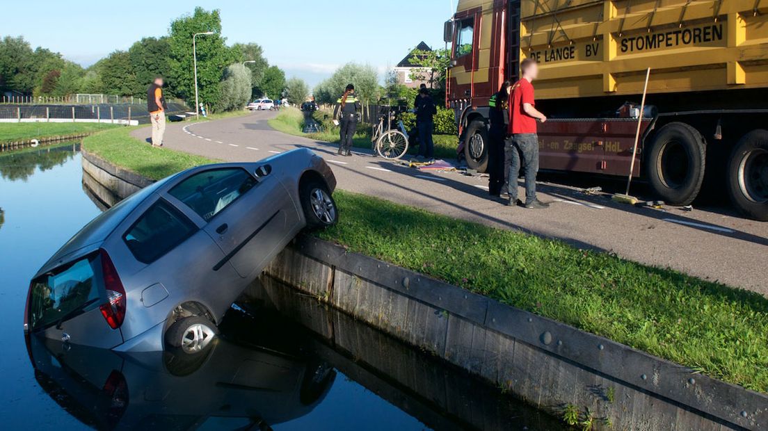 De auto belandde in het water na een botsing met een vrachtwagen