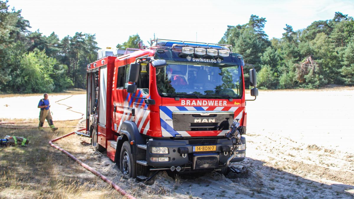 Brandweerwagen zit vast in het zand na blussen van natuurbrand