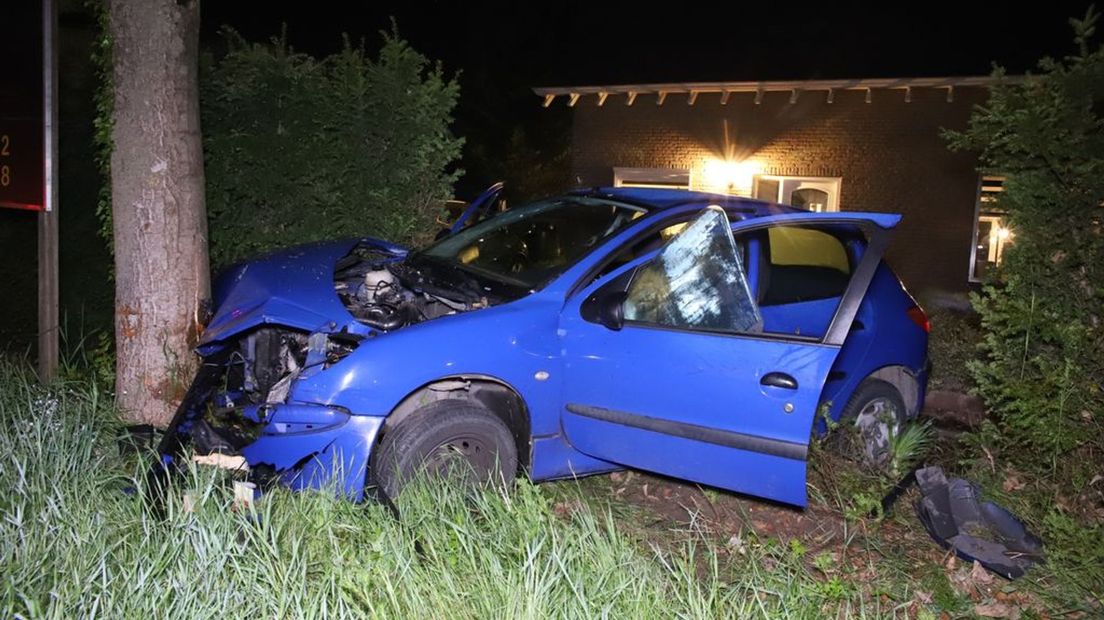 De gecrashte auto in de voortuin.