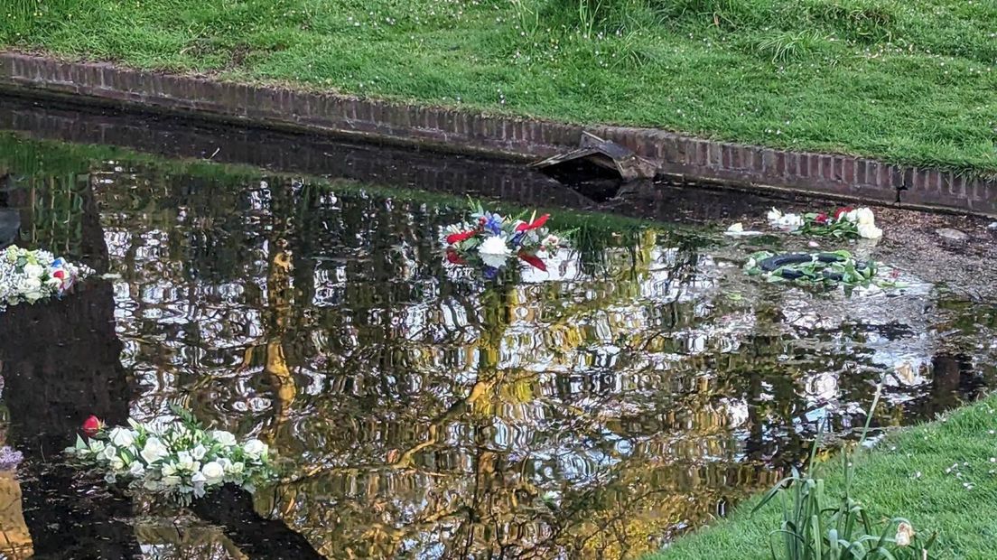 De kransen in het water van park Hofrust na de herdenking in 2023