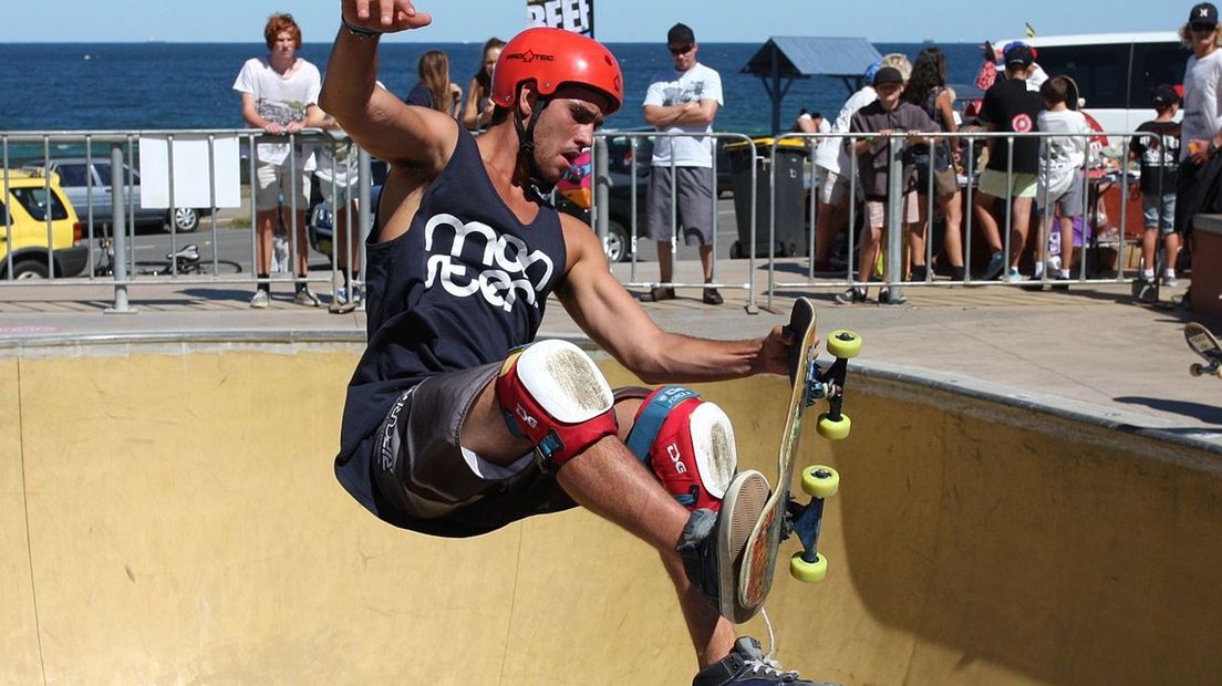 Een skateboarder doet een trick