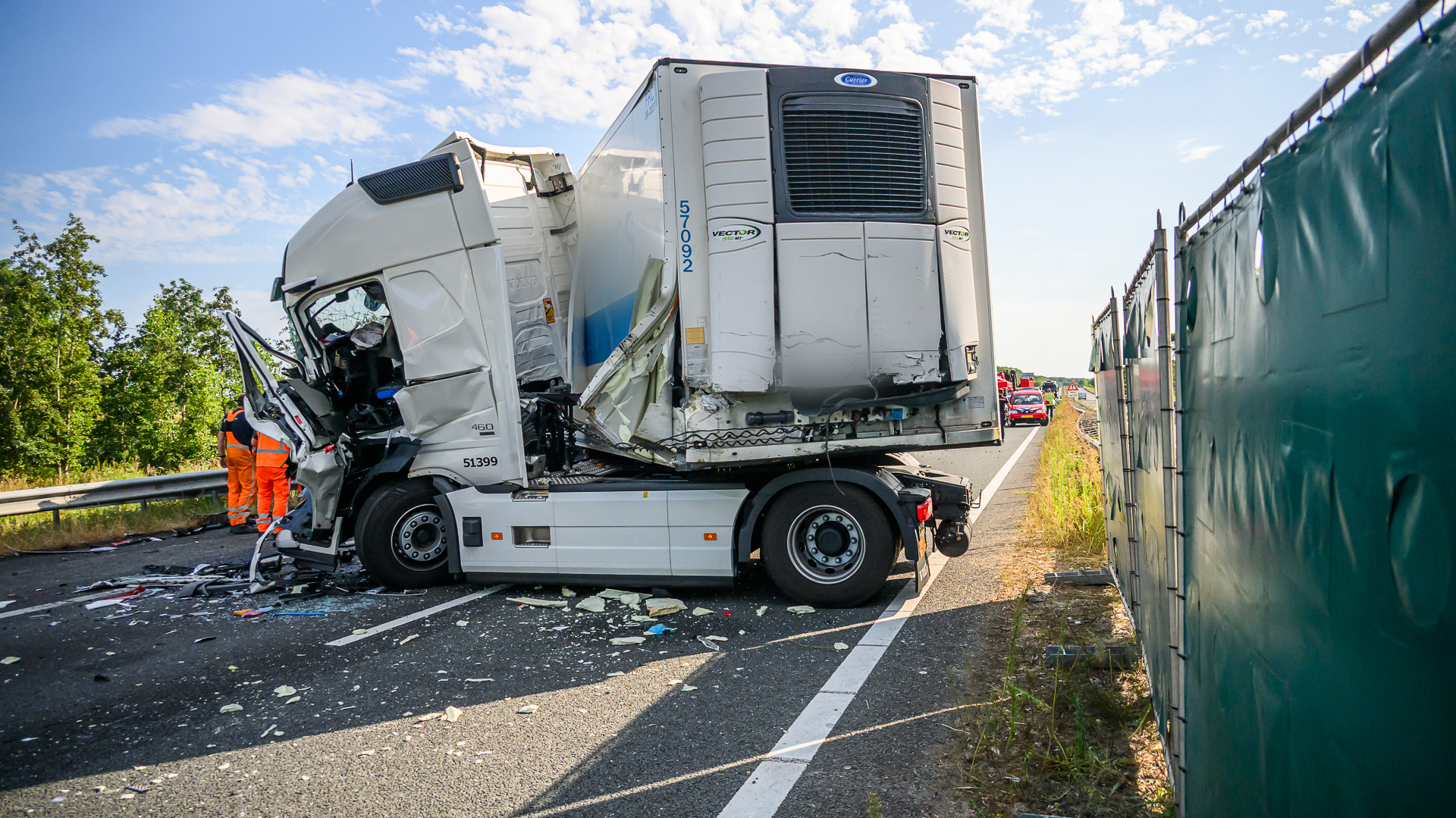 Door de botsing kwamen twee mensen bekneld te zitten, in een van de vrachtwagens ontstond brand.