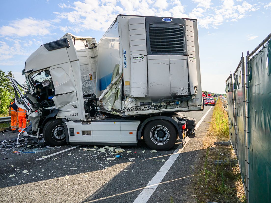 Door de botsing kwamen twee mensen bekneld te zitten, in een van de vrachtwagens ontstond brand.