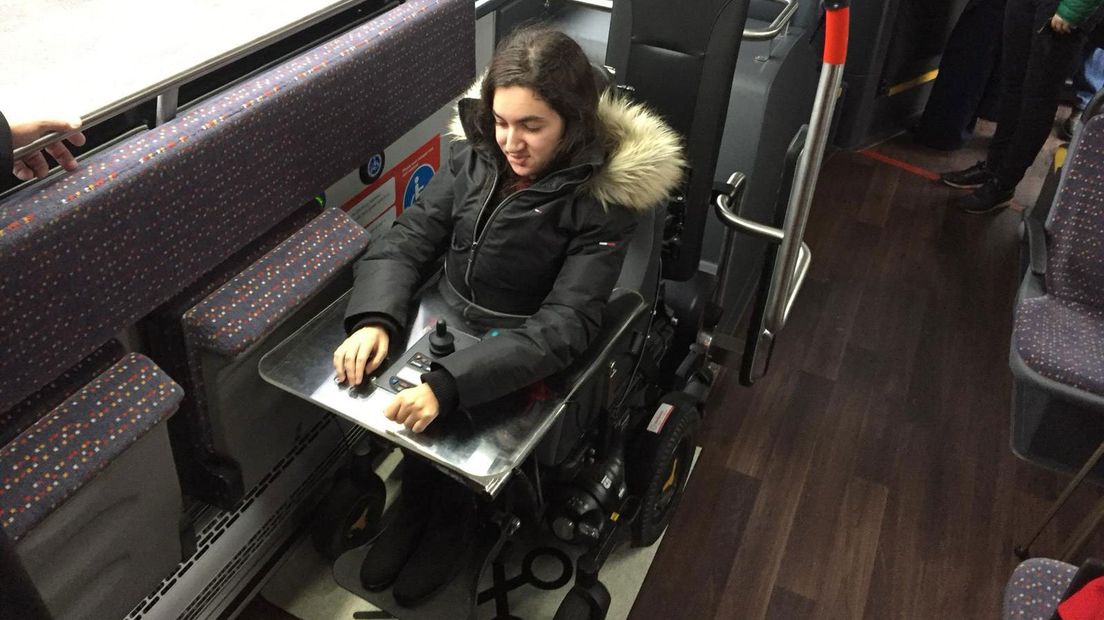 Salma Belmoussa met haar rolstoel in de elektrische bus