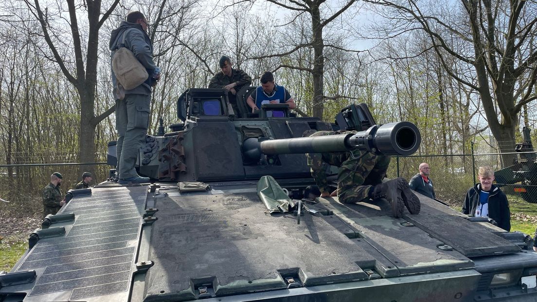 Jongeren vergapen zich aan een van de voertuigen van Defensie