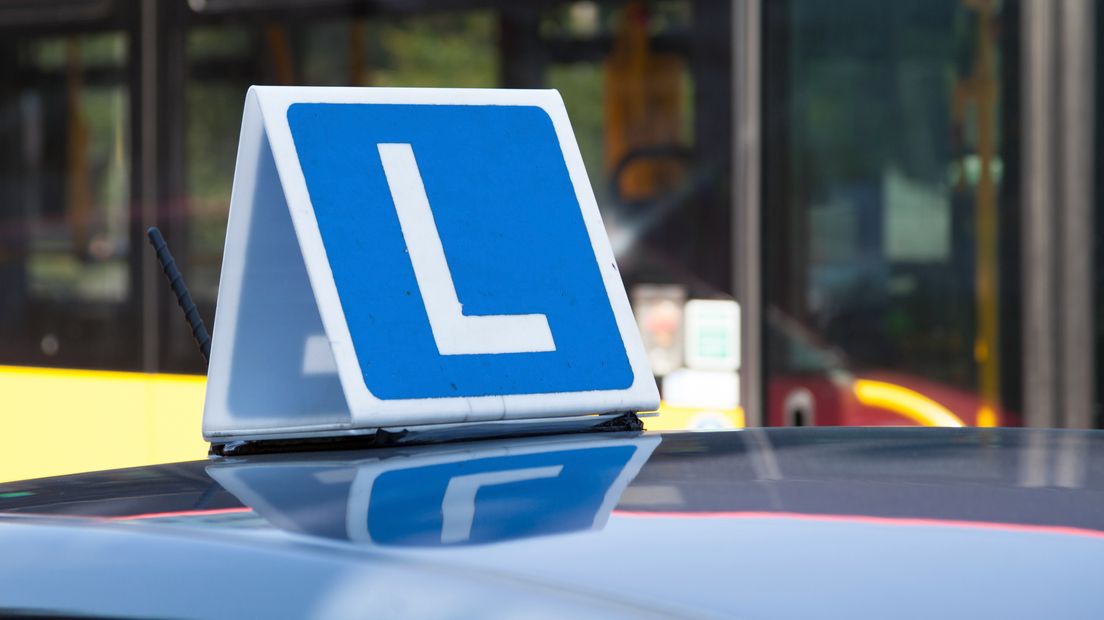 Rijinstructeur reed met lesauto fietser aan