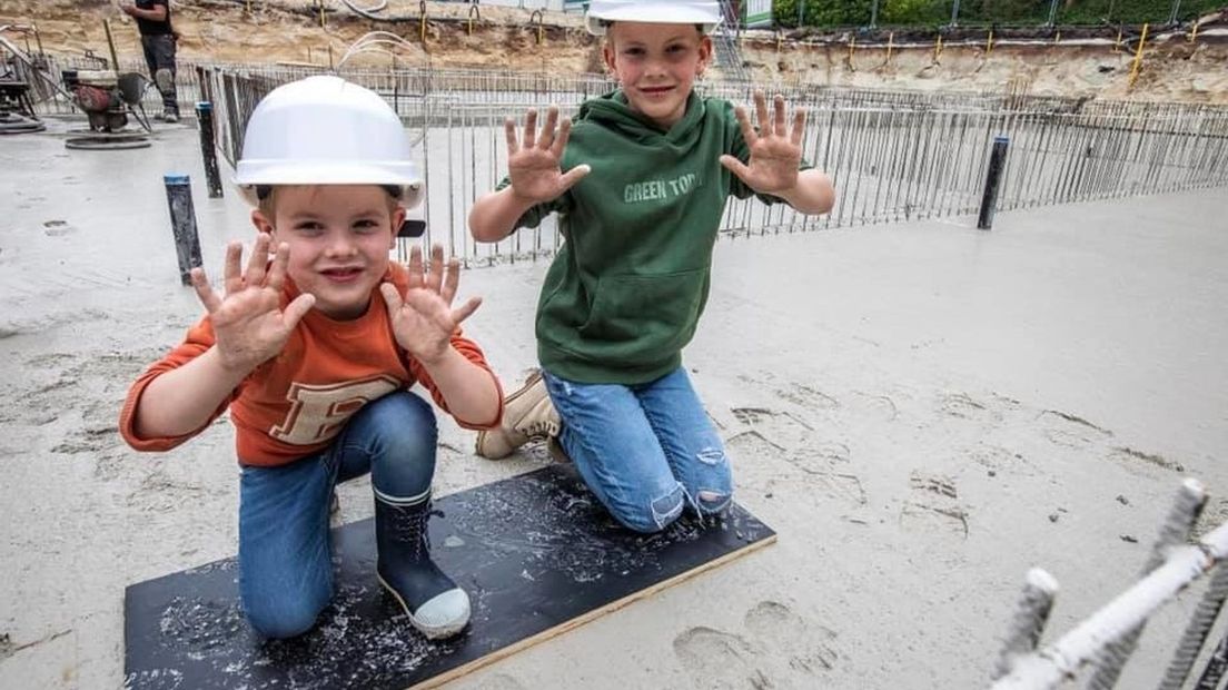 Zoons Mees en Faas zetten hun handafdrukken in het cement