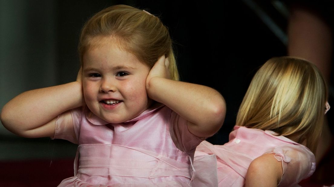 Prinses Amalia dekt haar oren tijdens het zingen bij de doop van haar zusje Ariane in 2007