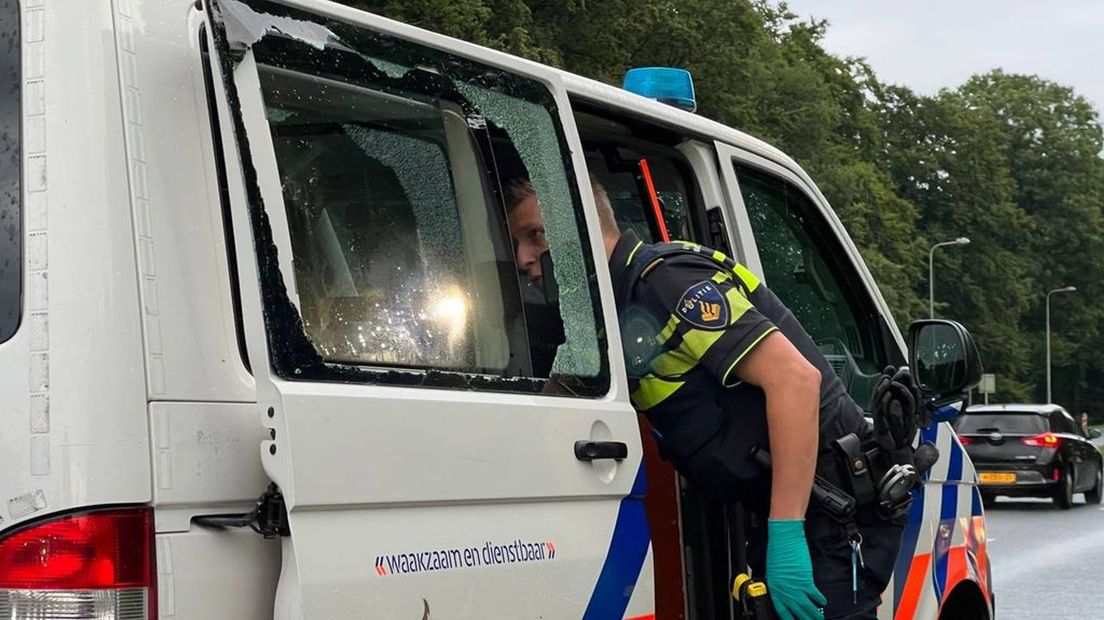 Een agent kijkt in de beschadigde bus