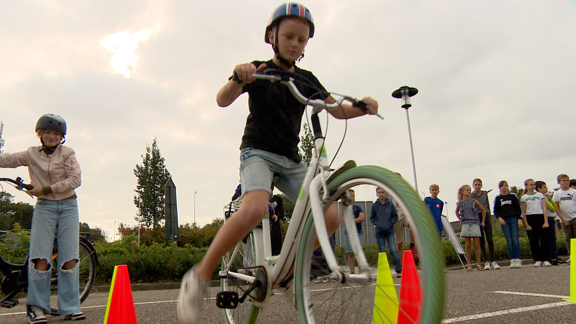 De leerlingen fietsen over een parcours met hindernissen