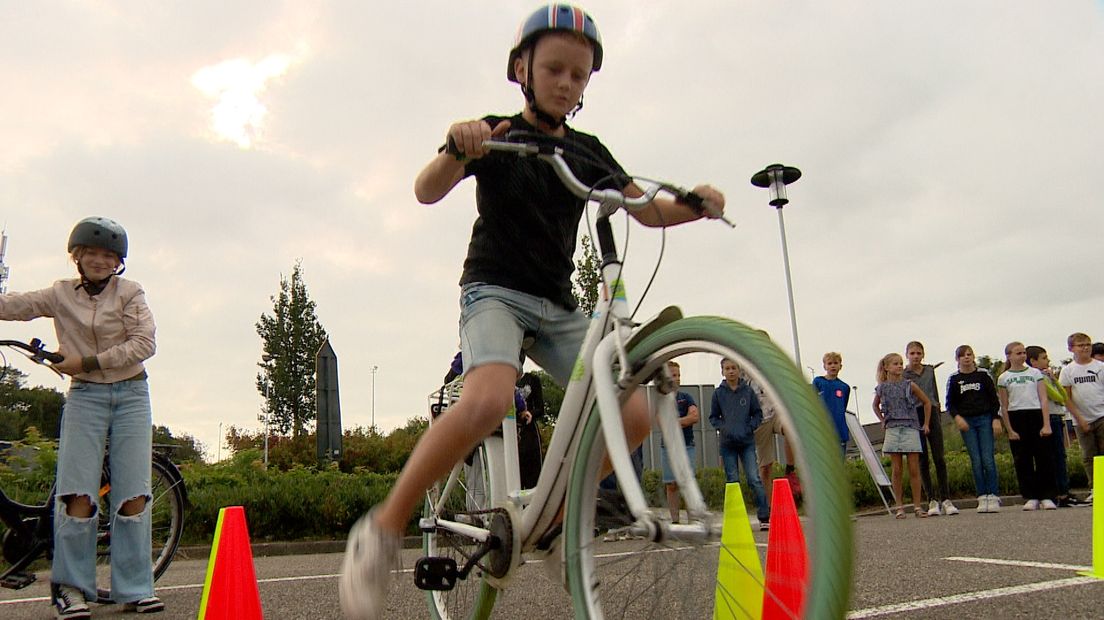 De leerlingen fietsen over een parcours met hindernissen