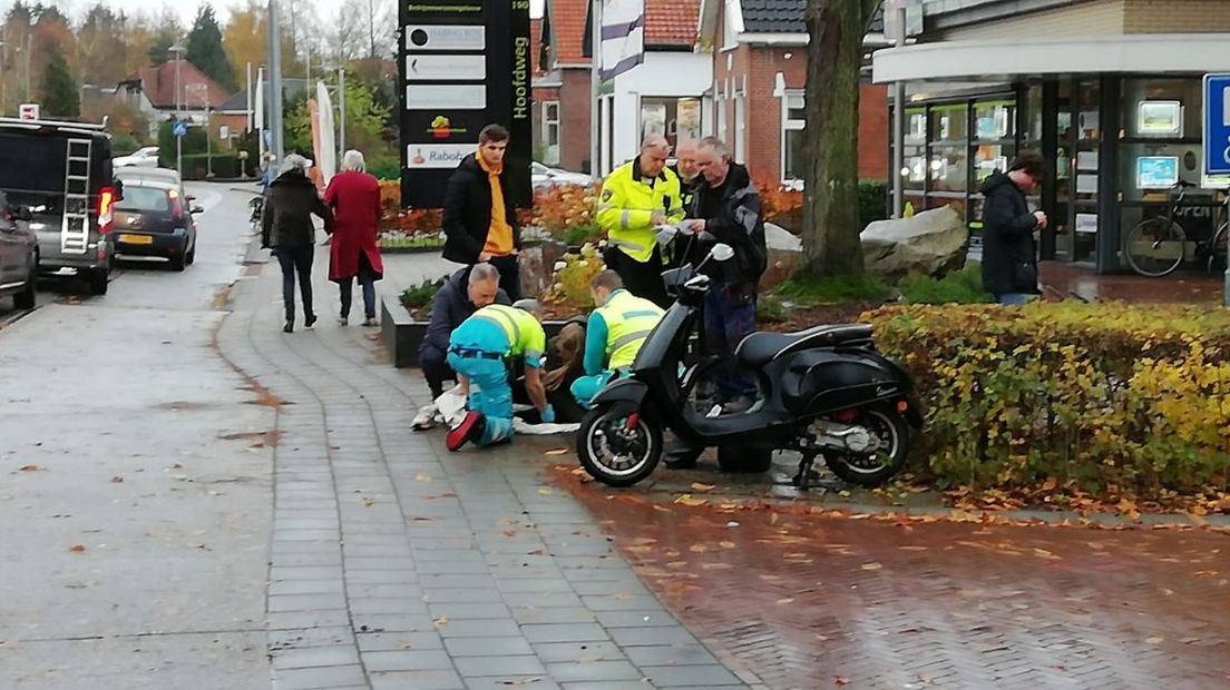 Ambulancepersoneel onderzoekt de gewonde scooterrijdster (Rechten: Van Oost Media)