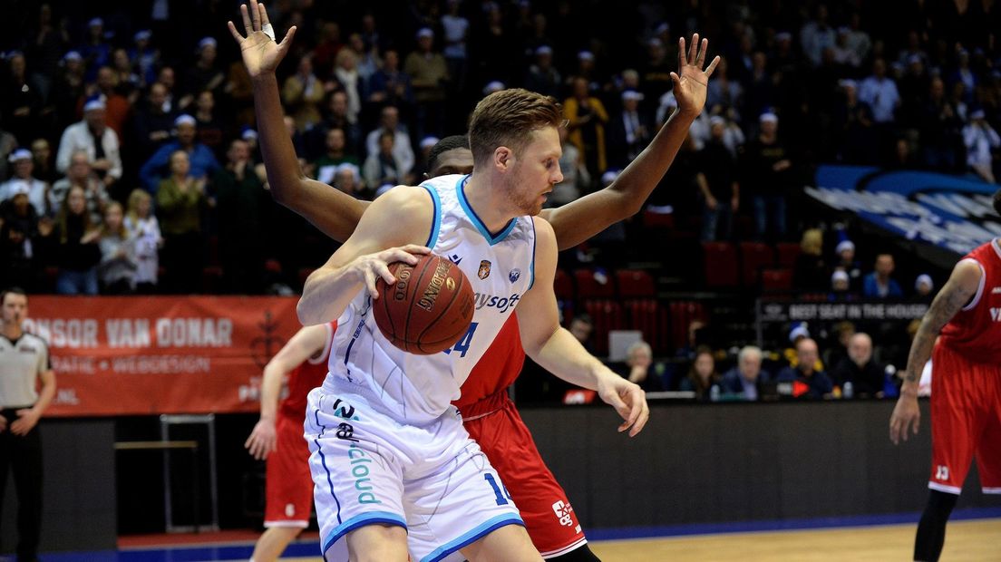 Thomas Koenis schermt de bal af voordat een speler van Aris erbij kan komen