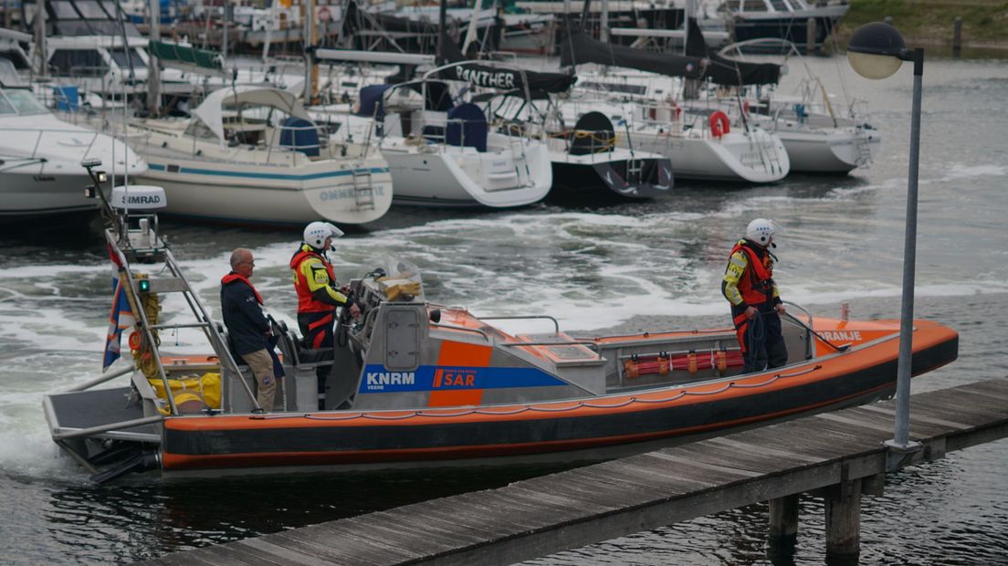 Drie schippers komen aan om het boek te overhandigen in de jachthaven van Veere