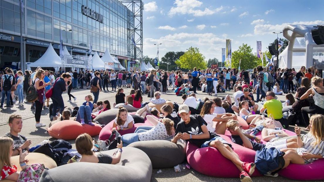 Jongeren chillend bij GelreDome voor de EO-jongerendag.