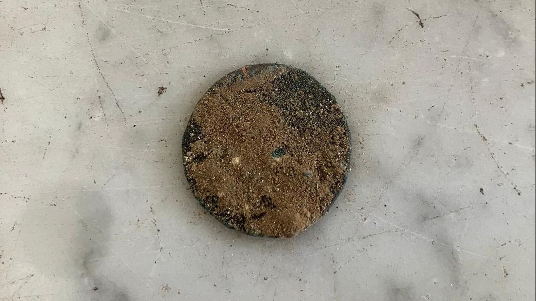 La moneda que se encontró junto al esqueleto. La moneda fue acuñada en la segunda mitad del siglo XVII por el príncipe-obispo de Lieja y probablemente se usaba para el culto al Rey Sol.