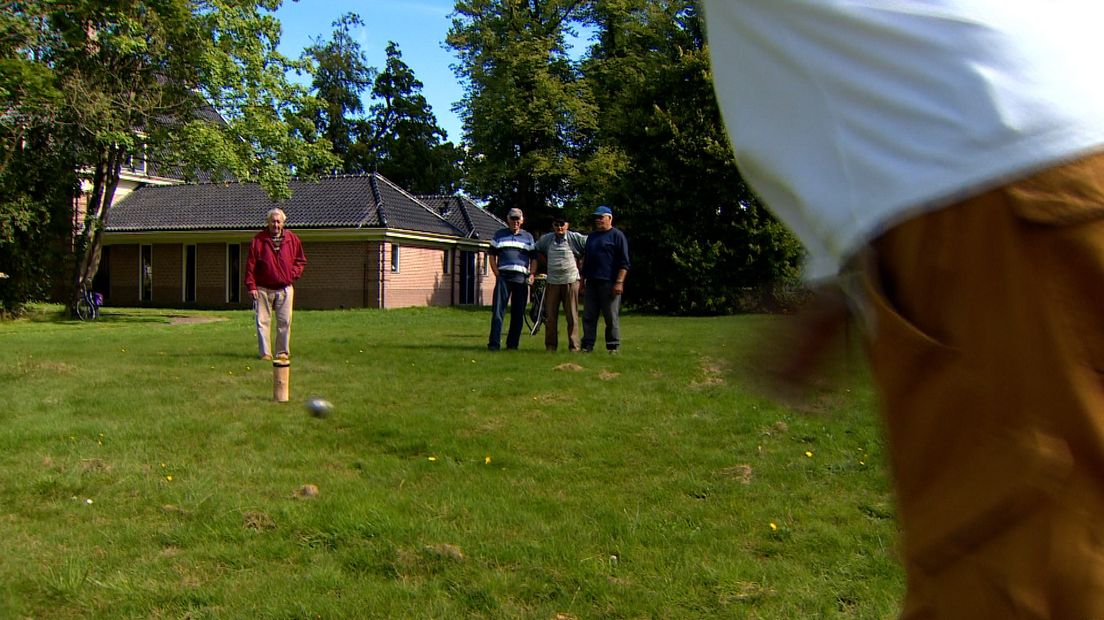 Het houten blok raken met een kei en zo de muntjes laten vallen is de essentie van het historische spel (Rechten: RTV Drenthe / Jeppe Oostenga)