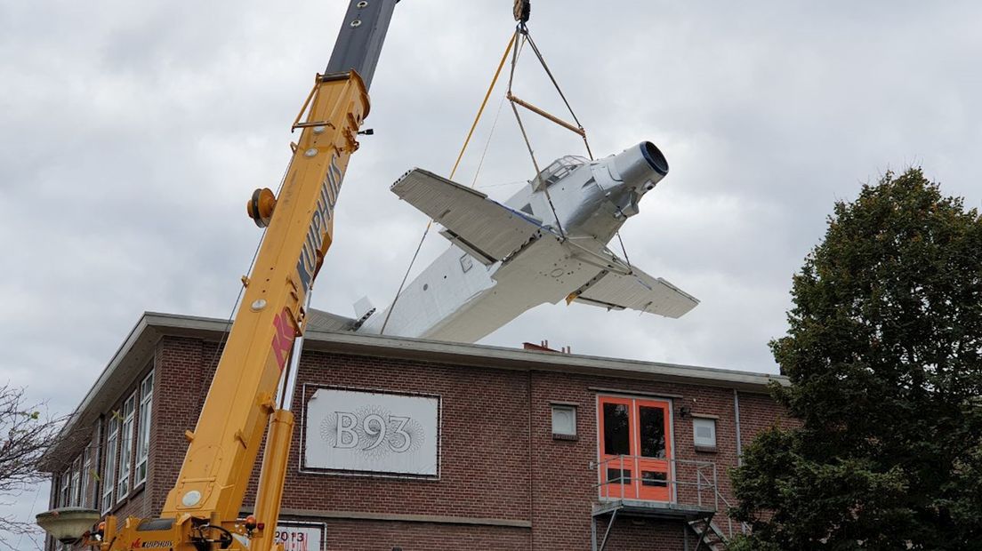 Past ‘ie wel of niet? Hijskraan takelt vliegtuig op oud schooltje in Enschede