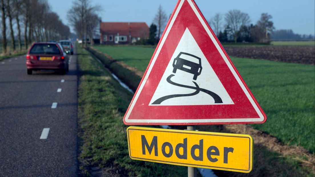 Een verkeersbord waarschuwt voor modder op de weg