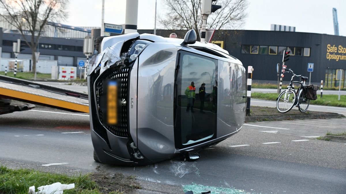 Auto ramt verkeerslicht en belandt op z'n zijkant