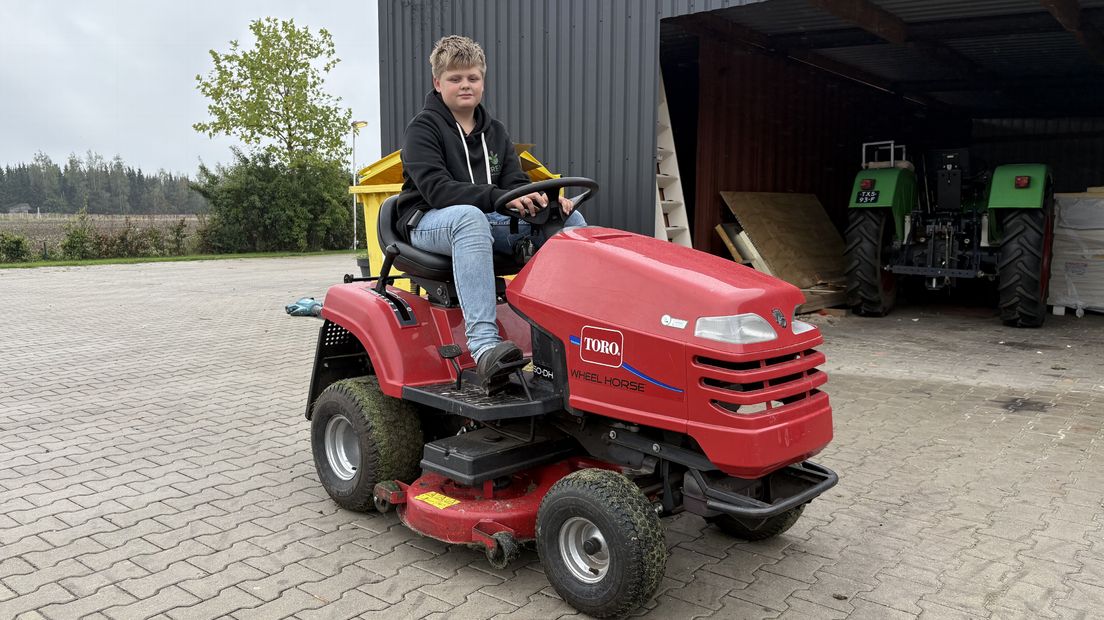Brent op zijn eigen rode grasmaaier