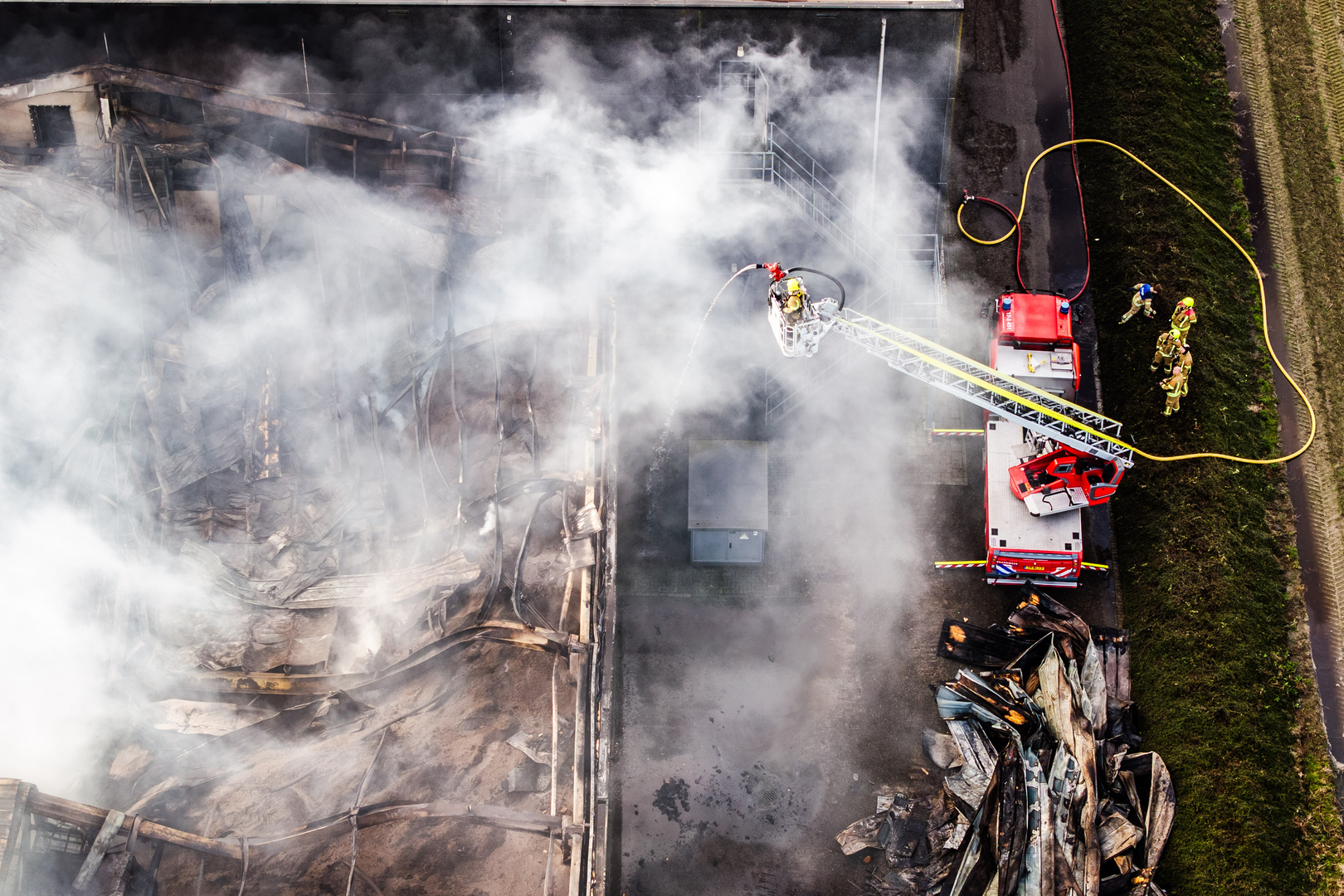 De brandweer heeft het vuur in de loods bijna helemaal geblust.