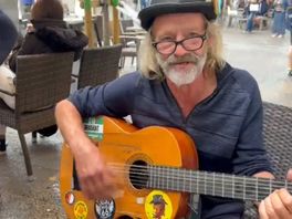 Straatmuzikant speelt een liedje voor een aantal Feyenoord-supporters