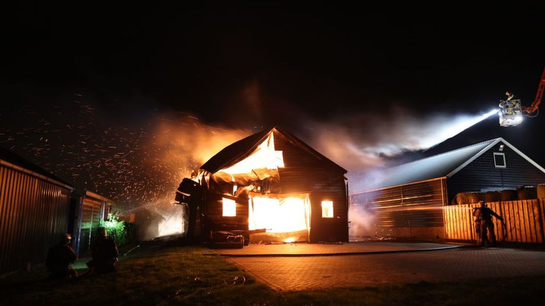 De brandweer zet onder meer een hoogwerker in om de vlammen te doven.