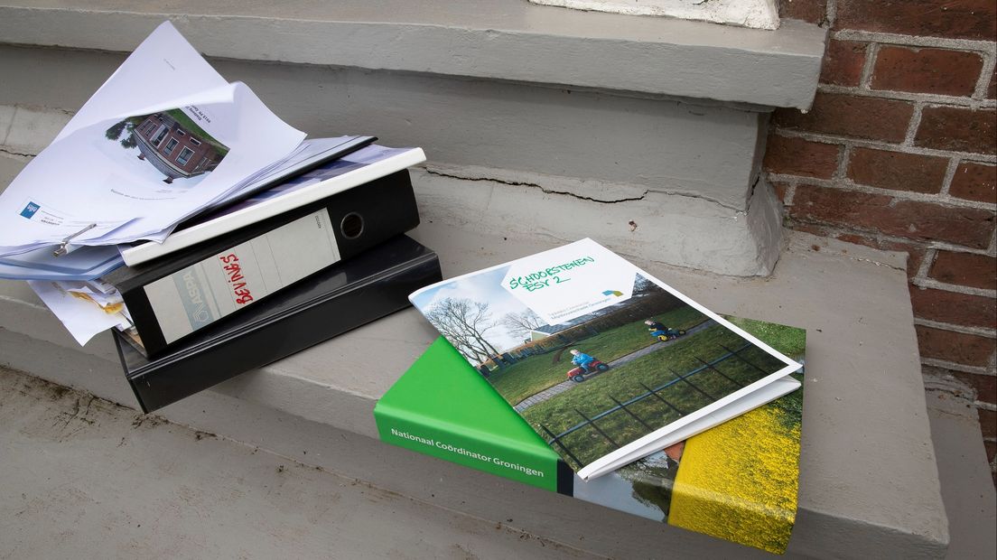 Ordners en dossiers bij een trap met bevingsschade