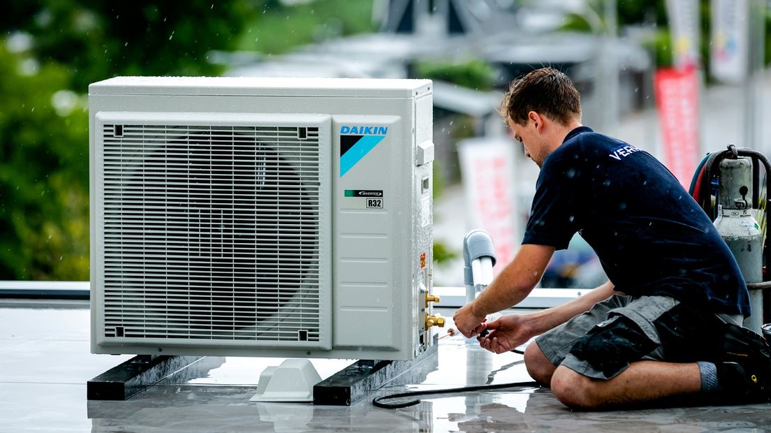 Een monteur installeert een airconditioner