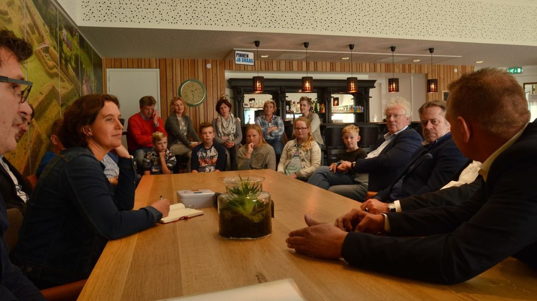 Den Besten (l.) luistert naar het verhaal van een delegatie van de school en wethouder Alex Wekema (Rechten: RTV Drenthe/Jeroen Kelderman)
