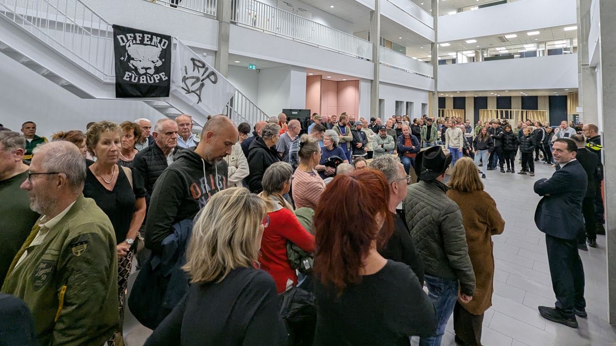 Schreeuwen, spandoeken en honderden boze mensen op tribune in gemeentehuis vanwege asielzoekers