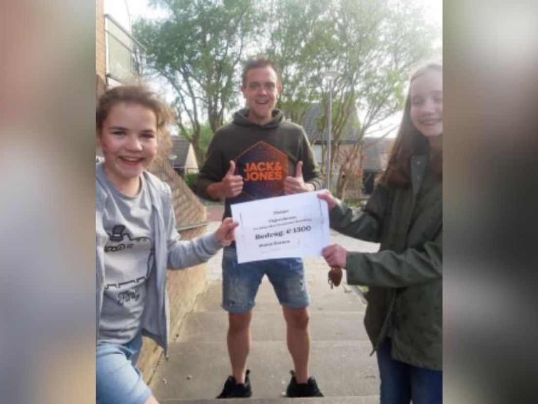 Jersey (l) met de opbrengst van de wafelactie. Rechts Rosalie, midden Bart van Harten, voorzitter van Scouting Rozenburg