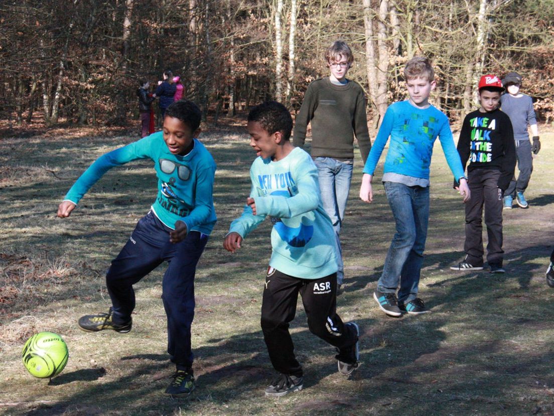 Quinten en Jurriën (in Feyenoordbroeken) voetballen tijdens schoolkamp
